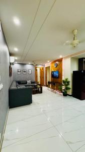 a large living room with a couch and a tv at Lux Haven Stays 2 Bedroom Luxury Apartment Near Gulberg - Ultimate Getaway Experience in Lahore