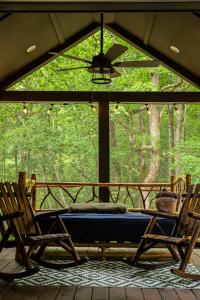 a screened in porch with two chairs and a mattress at Creekside Gem, Hot Tub, Sleeping Porch, Fire Pit in Mentone