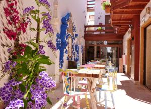 una fila de mesas y sillas en un restaurante con flores púrpuras en Villa Ana Margarida Hotel, en Ericeira