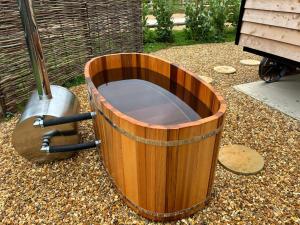 a wooden barrel sitting on top of a ground at Shepherd's Huts at Cotswold Hills Country Park in Chipping Norton +4 photos