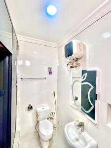 a white bathroom with a toilet and a sink at Vintage Classic Hotel in Lagos +164 photos