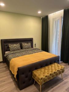 a bedroom with a large bed with a bench in it at Holiday home in Birstonas in Birštonas