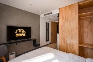 a bedroom with a bed and a tv on the wall at Xinxian inn Beijing Railway Station in Beijing