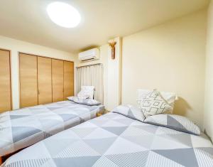 two beds sitting next to each other in a room at Asakusa 2DB Stuido Free Wi-Fi in Tokyo