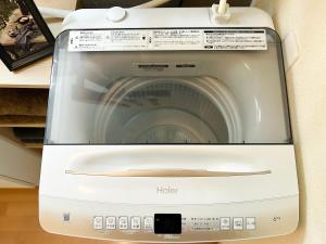 a white washing machine sitting on a shelf at Asakusa 2DB Stuido Free Wi-Fi in Tokyo