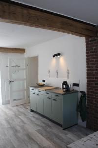 a kitchen with white cabinets and a counter top at Vakantie boerderij Pepinushof - 't Hofje in Maria-Hoop