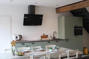 a kitchen with a table and chairs in a kitchen at Vakantie boerderij Pepinushof - 't Hofje in Maria-Hoop