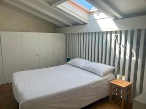 ein Schlafzimmer mit einem weißen Bett und einem Dachfenster in der Unterkunft Estúdio 24 na Boavista, JAMBA House in Porto