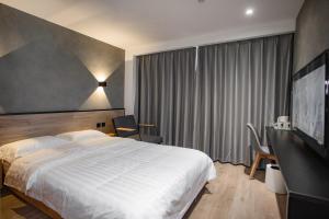 a hotel room with a bed and a large window at Xinxian inn Beijing Railway Station in Beijing +7 photos