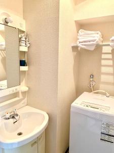 a bathroom with a sink and a washing machine at 5Close to Nagoya Station, with amazing views in Nagoya