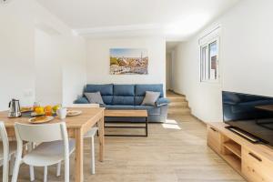 a living room with a blue couch and a table at AB Poble Sec - Plaza España in Barcelona