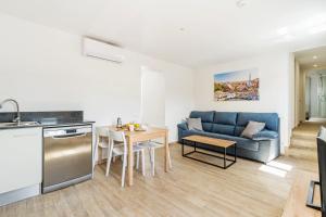a kitchen and living room with a couch and a table at AB Poble Sec - Plaza España in Barcelona +17 photos