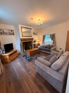 ein Wohnzimmer mit Sofa und Fernseher in der Unterkunft Wallnook Cottage Lindley Gem in Lindley