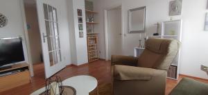 a living room with a chair and a television at Uns Lüttje in Norden