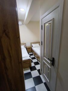 Habitación pequeña con 2 camas y puerta en Hotel, en Sergeli