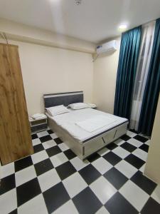 Un dormitorio con una cama y un suelo de cuadros. en Hotel, en Sergeli