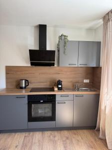 a kitchen with a stove and a sink at Hotel Weisses Lamm in Bruchsal +5 photos