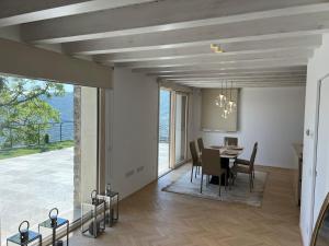 a dining room with a table and chairs and a large window at Villa Sebino Relais in Tavernola Bergamasca