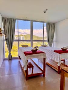 deux lits dans une chambre avec une grande fenêtre dans l'établissement Modern apartment near the beach, à Santa Marta