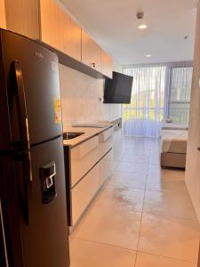 - une cuisine avec un réfrigérateur noir dans la chambre dans l'établissement Modern apartment near the beach, à Santa Marta