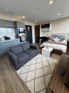a living room with a couch and a bed at Modern Studio with City Views in Sheffield