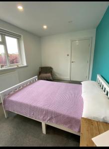 a bedroom with a large bed with a purple comforter at Modern private room in London