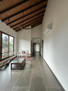 a living room with a table and a large window at Trabalho de Amor in Benaulim