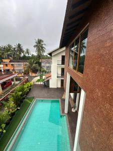 an external view of a house with a swimming pool at Trabalho de Amor in Benaulim
