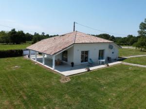 una piccola casa bianca con un ampio cortile di Gite de la teoulere a Bas-Mauco