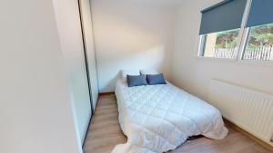 a small bedroom with a bed and a window at Merlyne Cote et Plage in Saint-Gilles-Croix-de-Vie