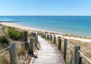 a wooden path leading to a beach with the ocean at Merlyne Cote et Plage in Saint-Gilles-Croix-de-Vie