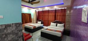 a hotel room with two beds and a couch at Hotel Nest near Park Street in Kolkata