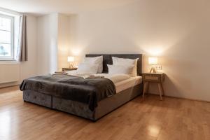 a bedroom with a large bed with two nightstands and two lamps at Holiday&Stay Apartment Big Blue Beamer 10 Personen in Blaubeuren