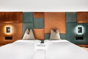 a room with two beds and a colorful wall at Ciasa Milandura NEW SUMMER 2025 in San Cassiano