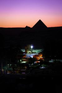 a view of a building with a mountain in the background at Pyramids Acme Inn in Nazlet el-Sîsi +15 photos