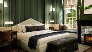 a bedroom with a bed with green walls and a fireplace at Cambridge Common House in Cambridge