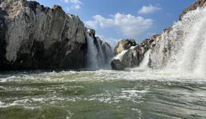 a waterfall in the middle of a body of water at S M LODGe in Dharmapuri