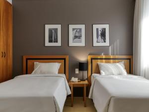 two beds sitting next to each other in a bedroom at Mercure Belo Horizonte Savassi in Belo Horizonte +99 photos