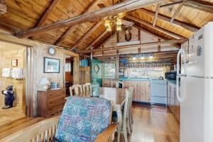 a kitchen with a table and a refrigerator at Rockwood Cabin on Moosehead Lake in Rockwood +23 photos