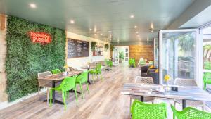 a restaurant with tables and chairs and a green wall at North Devon Resort One bedroom sea view hot tub Residence in Ilfracombe