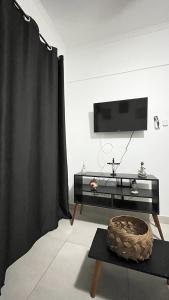 a living room with a black curtain and a tv at Mongaguá Apartamento in Mongaguá