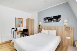 a bedroom with a white bed and a desk and a chair at Altona in Paris +68 photos