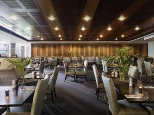 a restaurant with tables and chairs in a room at ibis Auckland Ellerslie in Auckland