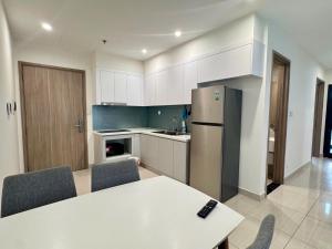 cocina con mesa blanca y nevera en Sora House 8 - Vinhomes Ocean Park, en Gia Lâm Pho