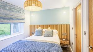 una camera da letto con un letto e una finestra di NDR Sea view Three bedroom Residence with private sauna & hot tub a Ilfracombe Altre 22 foto