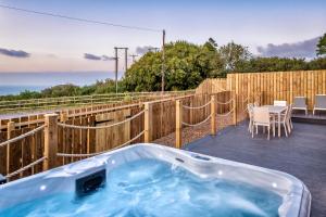 una vasca idromassaggio su una terrazza con tavolo e sedie di NDR Sea view Three bedroom Residence with private sauna & hot tub a Ilfracombe