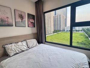 Un dormitorio con una cama y una ventana grande. en Sora House 8 - Vinhomes Ocean Park, en Gia Lâm Pho