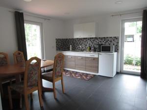 a kitchen with a table and a refrigerator and cabinets at Haus Kummer in Selm +16 photos