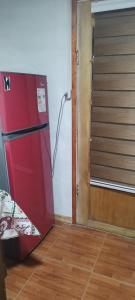 a red refrigerator in a room next to a door at Departamentos Aiken in Chile Chico