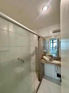 a bathroom with a glass shower and a sink at 957 golden fortaleza frente mar in Fortaleza +2 photos